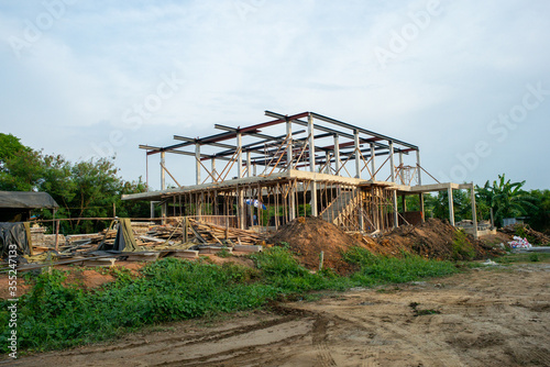 Perspective of house structure under construction at site with blue sky background