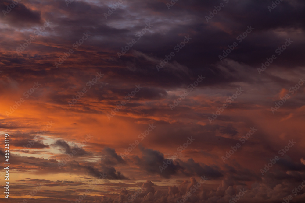 Dramatic sunset sky with orange clouds. Golden clouds in the sky.