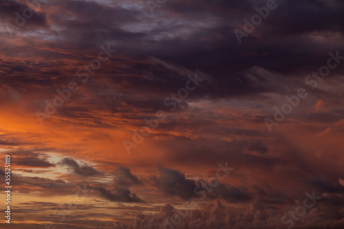 Dramatic sunset sky with orange clouds. Golden clouds in the sky.