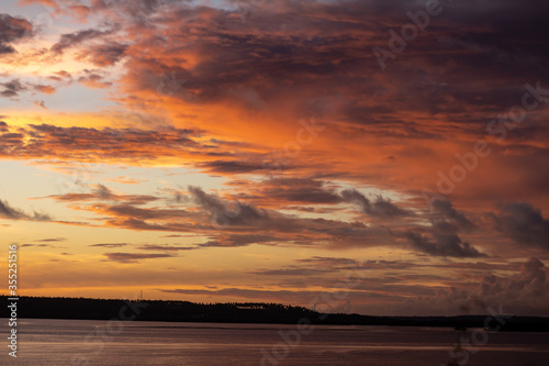 Dramatic sunset sky with orange clouds. Golden clouds in the sky.