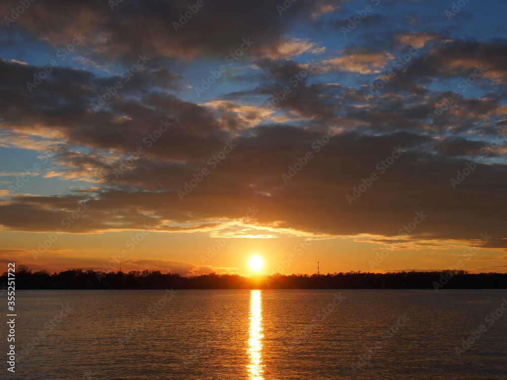 Michigan boaters enjoying a peaceful sunset on Lake Lansing in Haslett, Mi