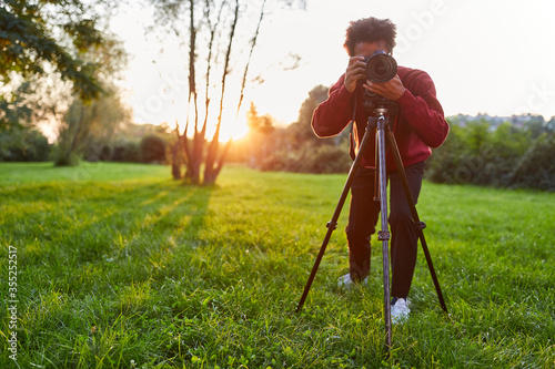 Junger Fotograf als Landschaftsfotograf mit Kamera photo