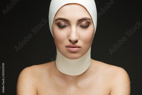 A beautiful woman after plastic surgery with a bandaged face. Beauty  Fashion and Plastic Surgery concept