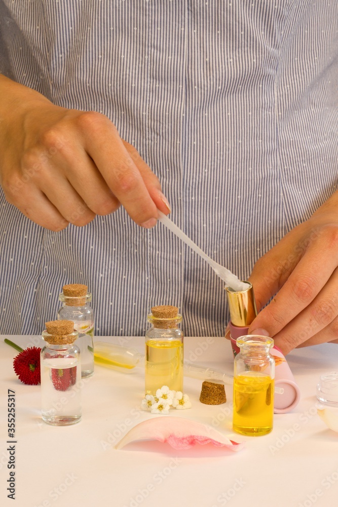 Beautiful and useful photo of a woman who makes homemade natural cosmetics and lipsticks from oils, essential oils, peppermint, rose water and aloe vera gel Beautiful and useful photo of a woman who makes homemade natural cosmetics and lipsticks from oils, essential oils, peppermint, rose water and aloe vera gel