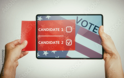 The human holds a digital tablet with paper ballot. Concept of e-voting via digital tablet. photo