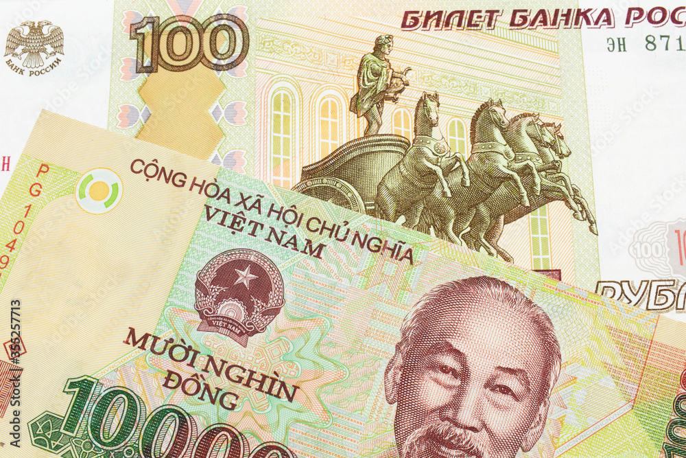 Fototapeta premium A macro image of a Russian one hundred ruble note paired up with a colorful, plastic ten thousand dong note from Vietnam. Shot close up in macro.