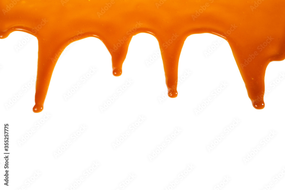 Background of flowing caramel sauce isolated on white.