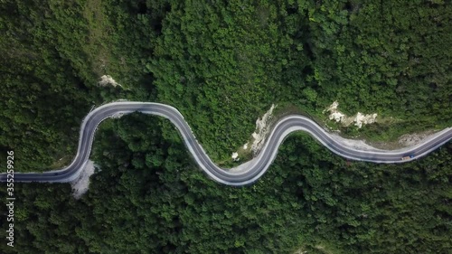 Mountain winding zig zag road. Top aerial view: cars driving on road from above.