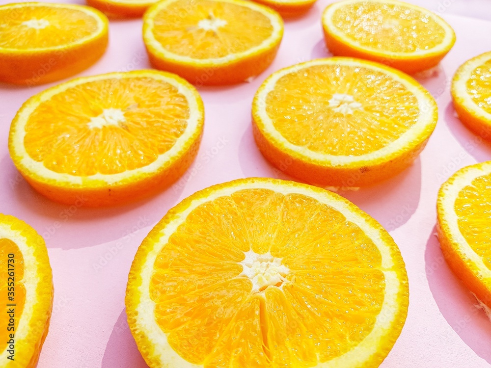 Slices of juicy orange oranges on a bright pink background. Slices of juicy orange oranges on a bright pink background.