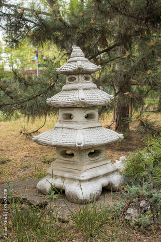 Japanese garden lantern close-up on a background of trees