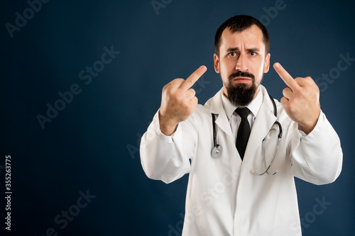 Male doctor with stethoscope in medical uniform showing double fuck you