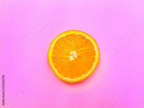 Slices of juicy orange on a bright pink background.