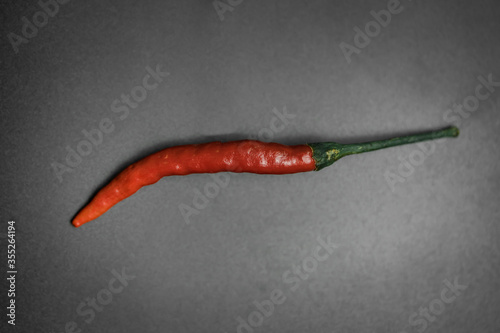 A close up of a red chilli in a black background