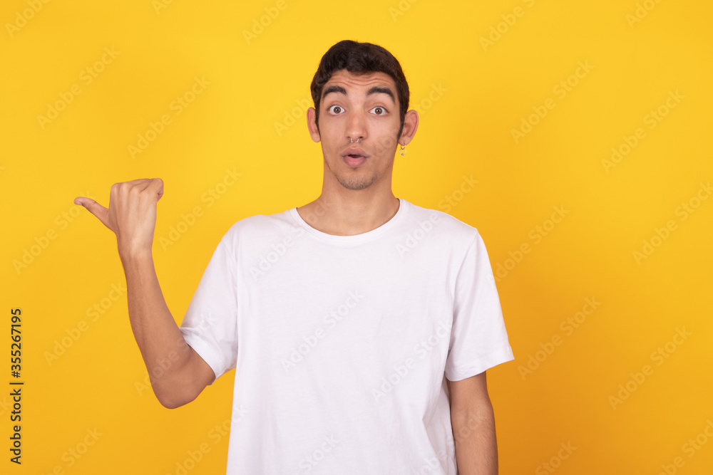 isolated young man pointing with surprise isolated young man pointing with surprise