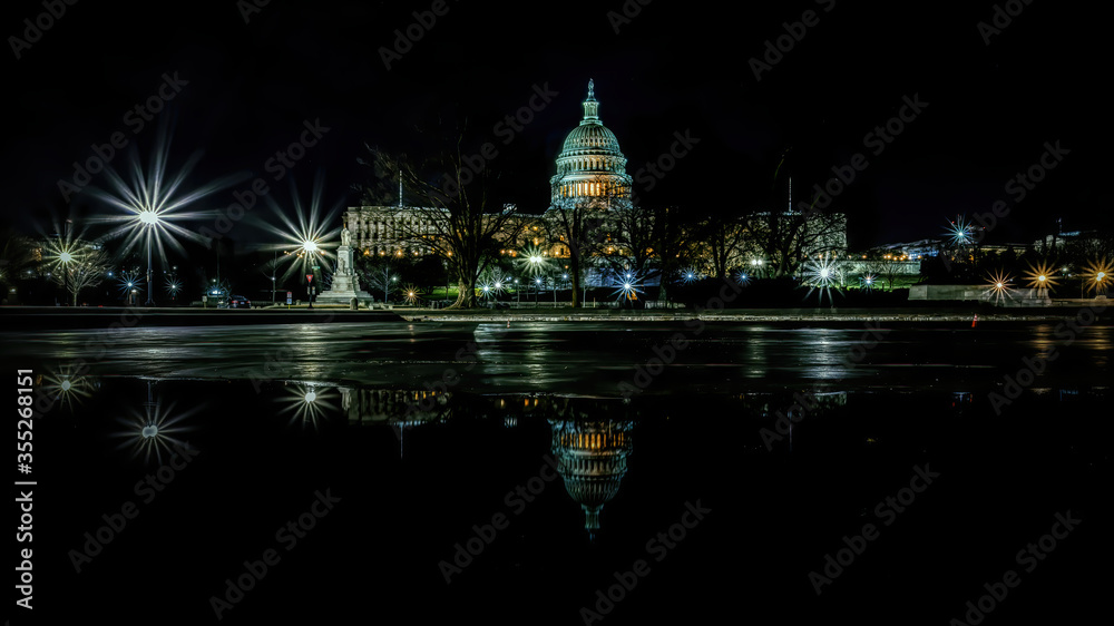 The capitol in Washington D.C., United States of America at a cold night in spring with reflections in water.