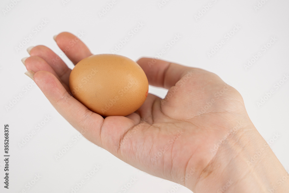 White and gray chicken eggs in a hand on a white background White and gray chicken eggs in a hand on a white background