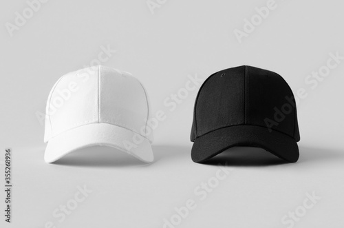 White and black baseball caps mockup on a grey background, front view.
