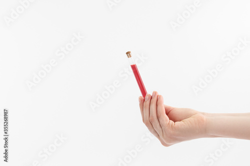Blood sample in hand on a gray background.