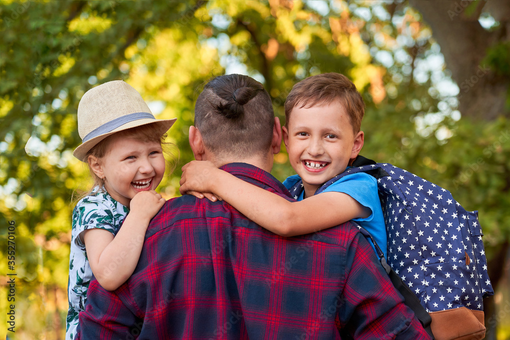 Fototapeta premium happy family of father and children.The father holds the children in his arms