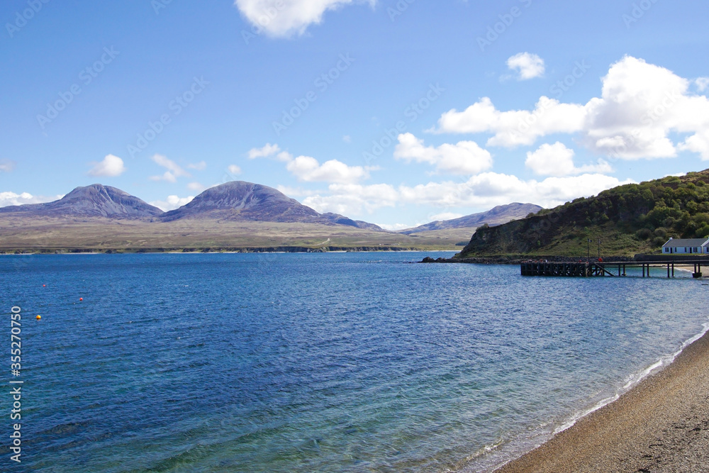 Bunnahabhain Bay and a pier of a distillery on the Isle of Islay with the Bunnahabhain Bay and a pier of a distillery on the Isle of Islay with the