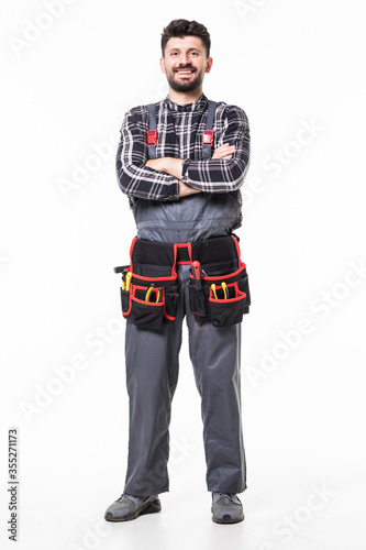 Full length portrait of handyman with tool belt on white background