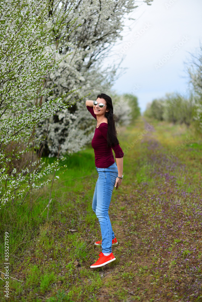Brown hair girl in sunglasses on the flower meadow