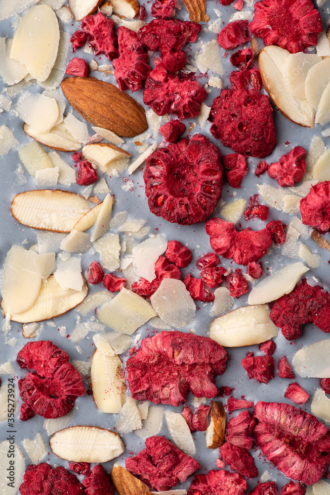 Craft white chocolate with freeze-dried raspberries and almond. Flat lay. Macro.