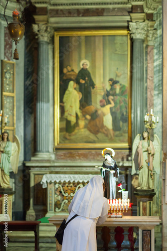 ROME, ITALY - 2014 AUGUST 17. Nun lights a candle in the Church in Rome.
