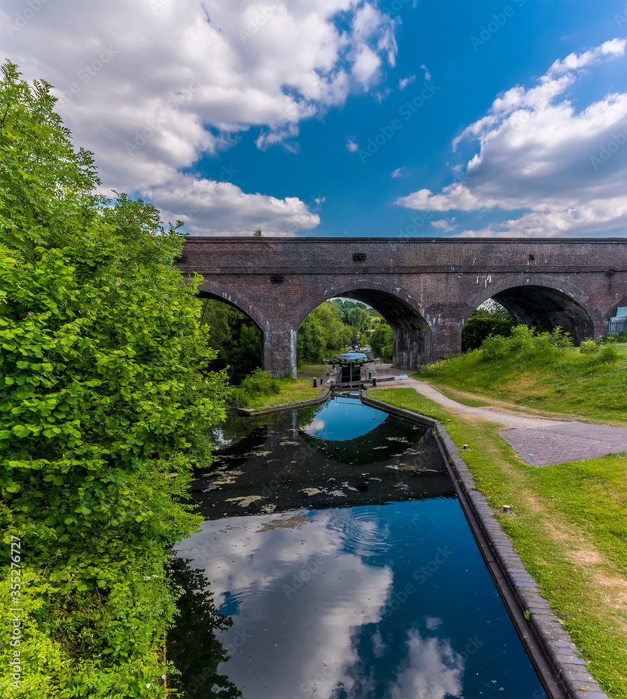 Fototapeta premium A view down the Dudley canal towards the Park Head Viaduct at Dudley, UK in summertime