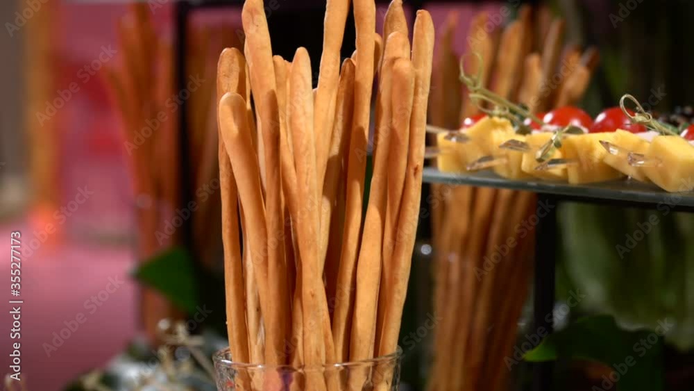 Italian crispy breadsticks, closeup. Grissini and snacks of cheese