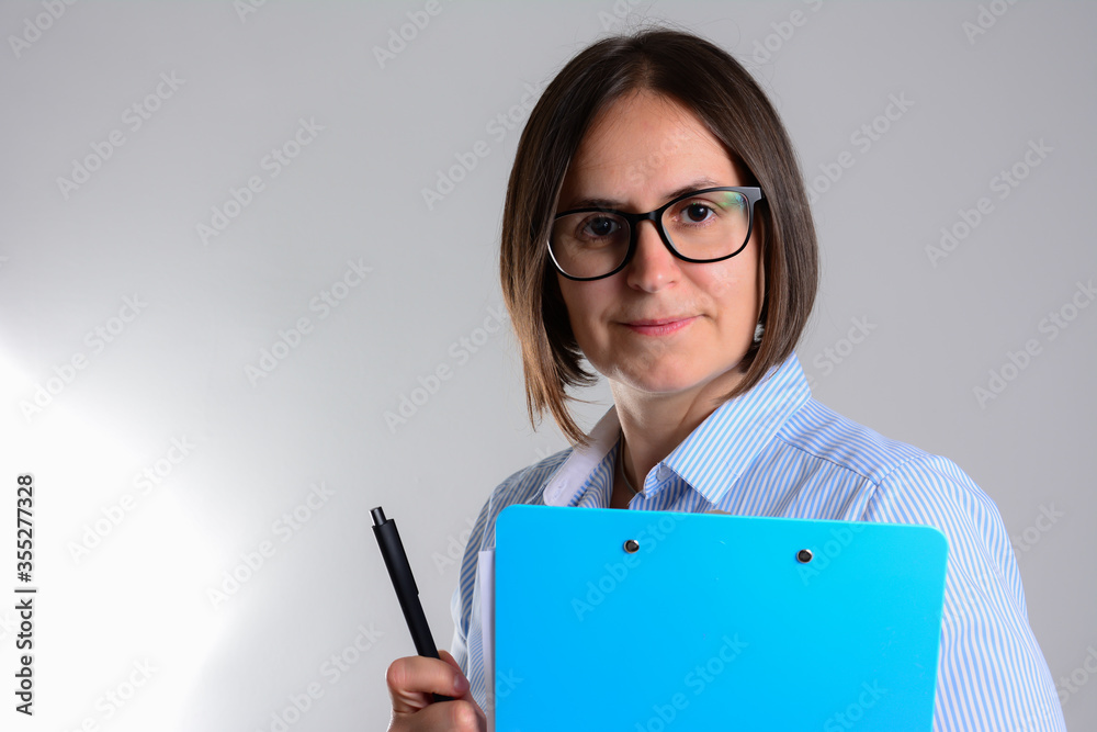 Business woman with clipboard. young attractive business woman with pencil and clipboard isolated on grey background. Happy beautiful business woman with clipboard Business woman with clipboard. young attractive business woman with pencil and clipboard isolated on grey background. Happy beautiful business woman with clipboard