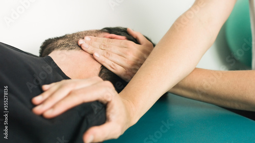 Physiotherapist doing massage and stretching with person on a therapy table.