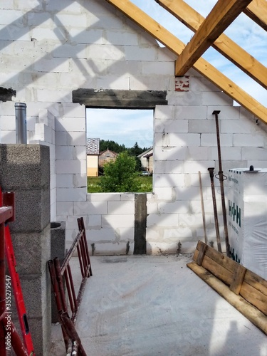 Attic under construction. house in basic state. Wooden roof construction, rafters, blocks and wreath. View of nearings through the roof.