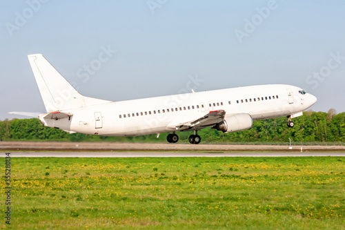 Take-off from the runway of a white passenger aircraft on a clear summer day