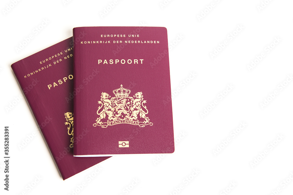 Two closed european passports from the netherlands lying on a white background Two closed european passports from the netherlands lying on a white background