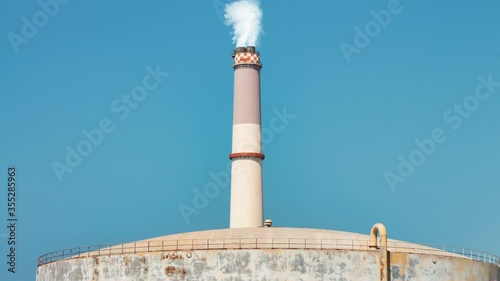 Cinemagraph of smoke emitted from the chimney of the Reading power plant. It located near a large natural gas storage tank in Tel Aviv, Israel. Loop.