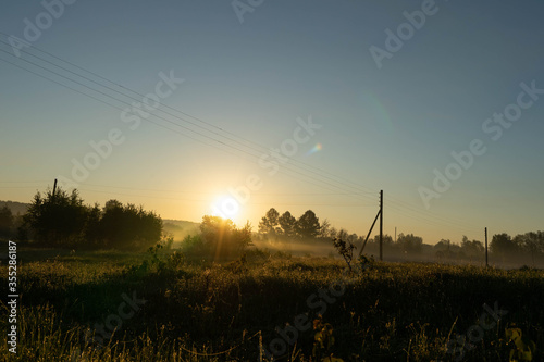 dawn on the background of a field with power lines