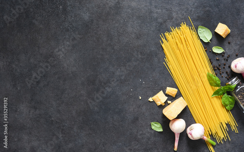 Ingredients for making pasta. Raw spaghetti with on a black background. View from above.