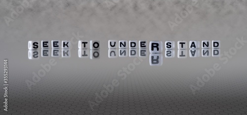 Φωτογραφία seek to understand concept represented by black and white letter cubes on a grey