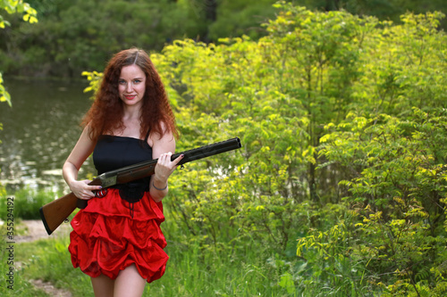 girl with a hunting rifle in hands outdoors