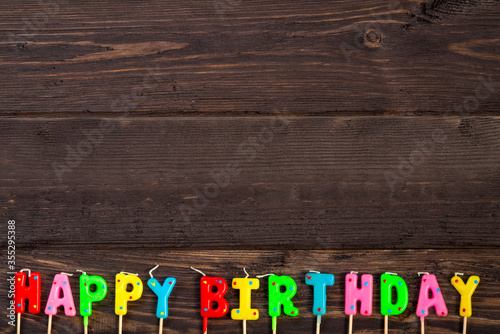 happy birthday candle letters on dark wooden boards