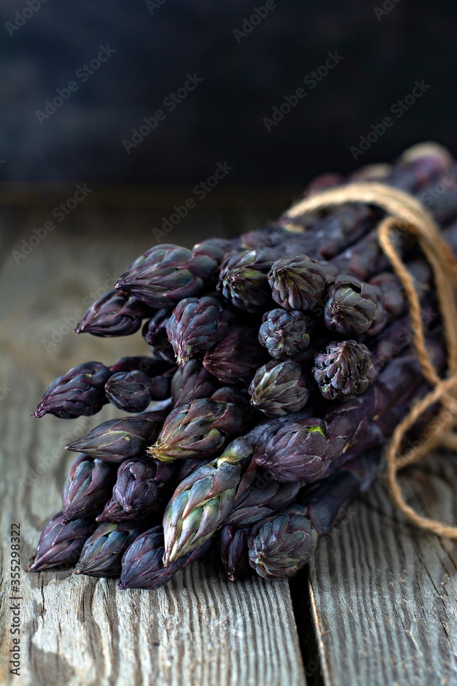 Fresh bunch of purple asparagus on a wooden background. Fresh bunch of purple asparagus on a wooden background.