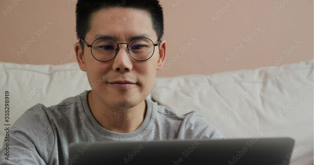 Asian business man using laptop to work at home. Young man freelancer student using laptop studying online working from home in internet Asian business man using laptop to work at home. Young man freelancer student using laptop studying online working from home in internet
