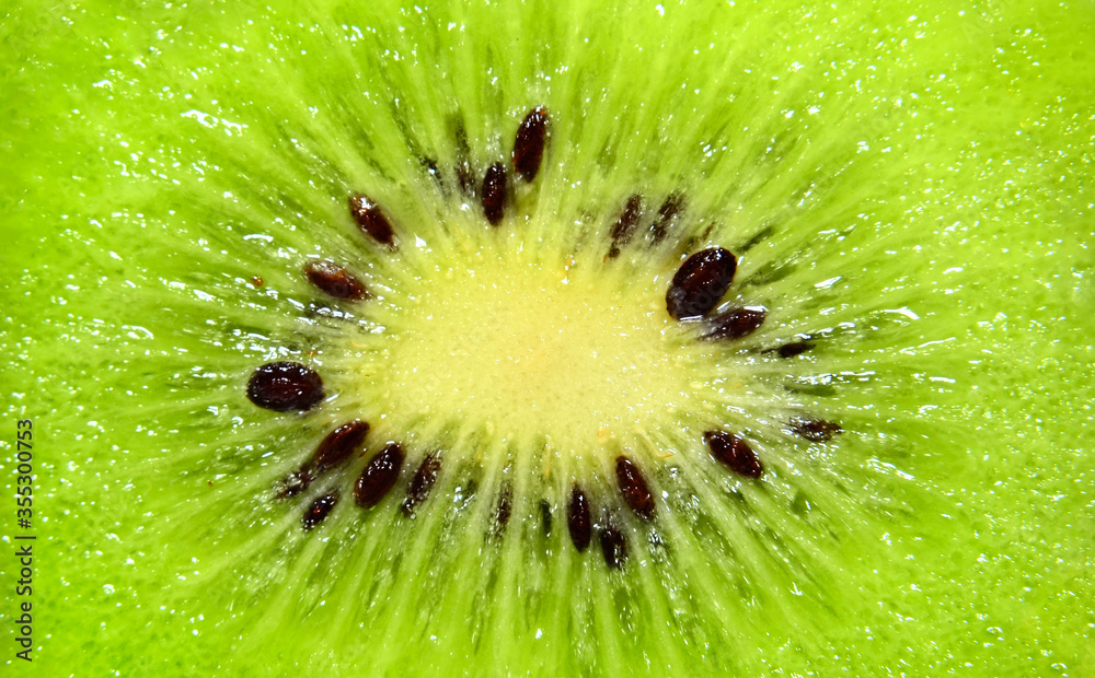 Fresh juicy fruit slice closeup. Slice of kiwi fruit on a full frame. Fresh juicy fruit slice closeup. Slice of kiwi fruit on a full frame.