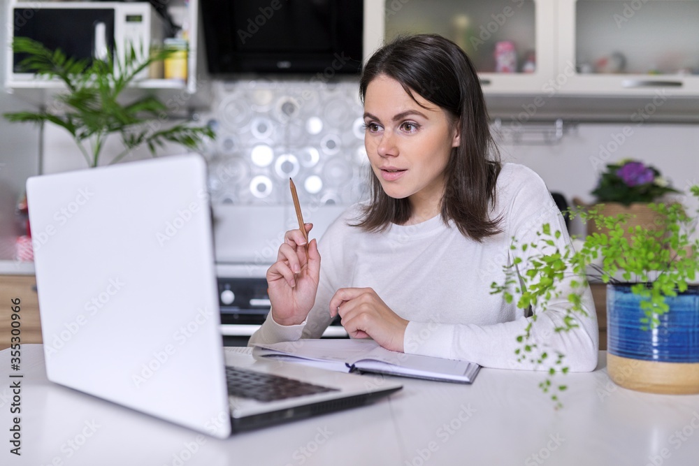 Young female working in home office using laptop, business woman, teacher Young female working in home office using laptop, business woman, teacher