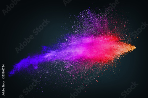 Abstract design of bright colored powder cloud on dark background