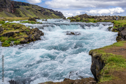 Tourist looks on unnamed waterfall next to so called Ring Road in southern Iceland