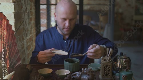 Bolde man doing a traditional chinese tea ceremony photo