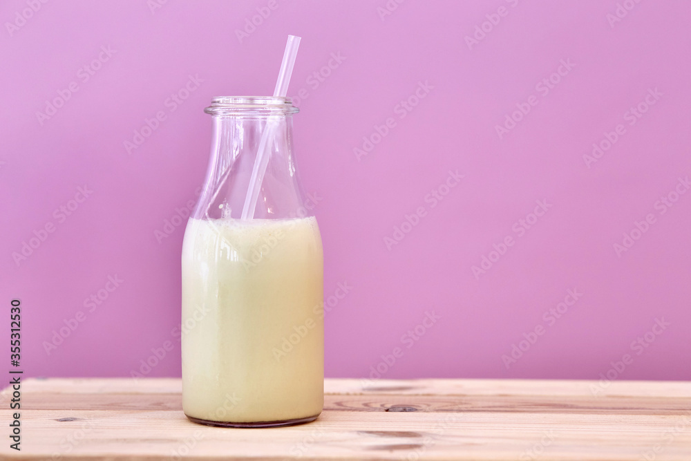 Closeup of a bottle of milk with a pink background. Closeup of a bottle of milk with a pink background.