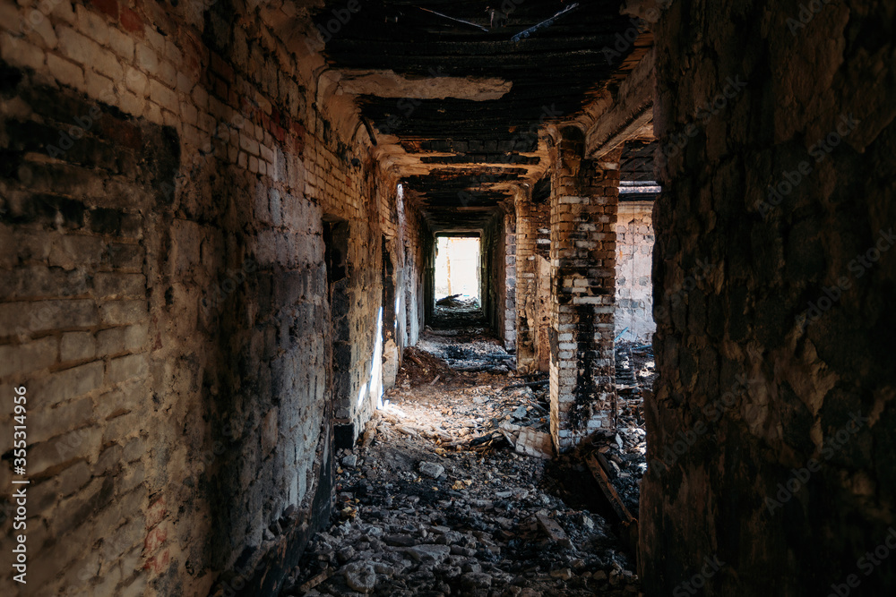 Burnt old house interior. Ruined coridor walls in black soot. Consequences of fire Burnt old house interior. Ruined coridor walls in black soot. Consequences of fire